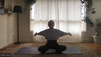 Screenshot of woman seated in yoga pose