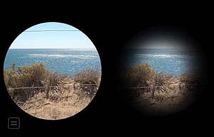 Two round images on a black background. Both images are of a blue ocean in the background with an area reflecting white from the sun. The sky above is light blue, and a black telephone wire runs across the top. In the foreground is a sand dune with brown spikey bushes. The image on the left completely fills the circle. The image on the right has dark, blurry edges that hide about 50% of the image including the sand in the foreground, the edges of the bushes and the wire overhead.