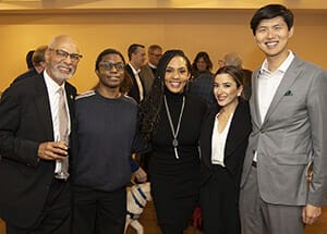 DID 2020 - smiling group Two men and three women in dressy clothes smile with their arms around each other.