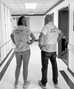 Black and white photo of Keith and Tina in white t-shirts with the Leader Dog logo in an old font style.