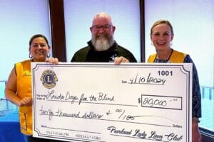 Barry and two Pearland Lady Lions members holding an oversized check